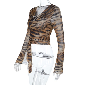 Vista laterale del crop top in mesh a stampa tigre con maniche lunghe e laccio in vita