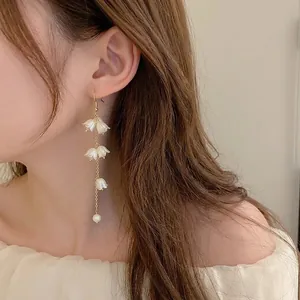 Boucles d'oreilles muguet élégantes avec pétales blancs et perles pendantes sur chaînes dorées