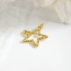 Detailed macro shot of a gold-plated hollow star pendant with textured metal surface