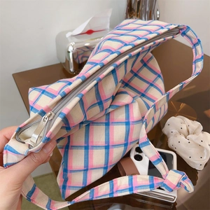 Detailed close-up of a plaid cotton canvas crossbody bag with pink and blue grid patterns