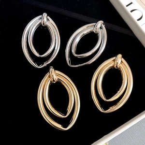 Détail de boucles d'oreilles ovales étagées or et argent sur plateau en velours