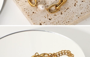Gros plan d'un bracelet à chaîne épaisse plaqué or 18 carats avec perle ovale