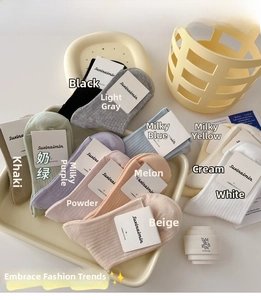 Flat lay of colorful ribbed cotton socks in twelve pastel shades with brand tags