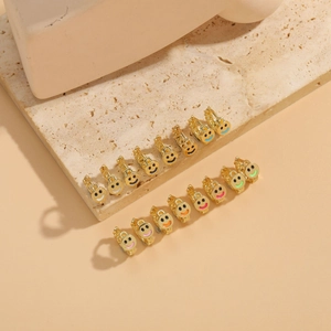 Macro shot of assorted colorful enamel smiley face earrings on marble stone display
