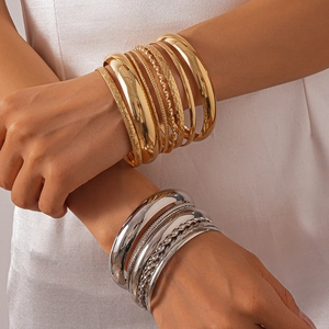 Detail of 8-piece stackable metal bangles with textured finish on model's wrist