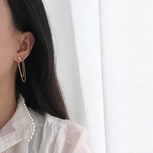Minimalist 18K gold plated titanium tassel chain earrings on model with white pearl shirt