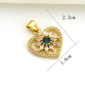 Detailed view of heart-shaped gold pendant with green gem, 2.3cm height and 1.8cm width