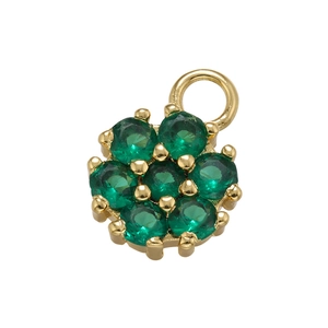 Macro shot of a golden flower pendant set with seven emerald green round zircons