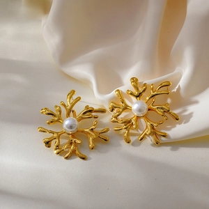 Golden snowflake floral earrings with white pearls on elegant white silk fabric