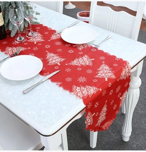 Detail of red Christmas table runner featuring white tree patterns and wavy scalloped edges
