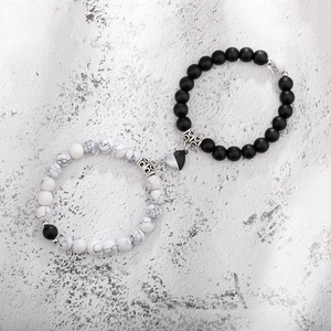 Detail of magnetic heart clasp connecting black lava stone and white turquoise bead bracelets