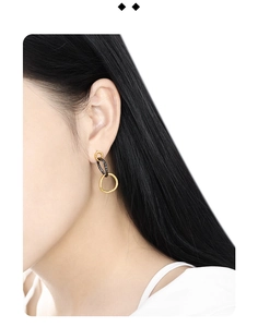 Close-up of minimalist black and gold triple hoop S925 silver earrings on a model