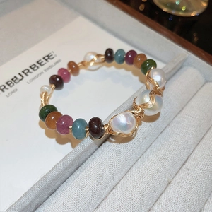 Detailed wire-wrapped bracelet with colorful stone beads and baroque pearls on display