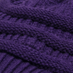 Detailed macro shot of thick dark purple cable knit texture on a winter beanie hat