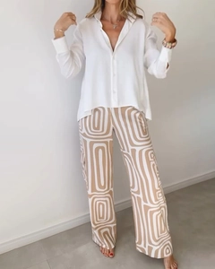 Detail of white shirt and coffee geometric print wide-leg trousers on model