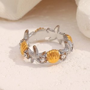 Detailed close-up of 18K gold starfish and seashell ring with sparkling crystals