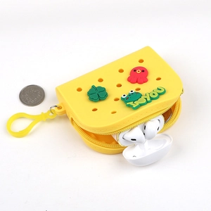 Macro detail of yellow silicone coin purse showing clover and frog charms with clover charms