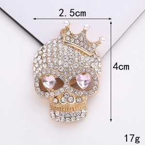 Détail du pendentif crâne doré avec cœur rose et perles montrant les dimensions