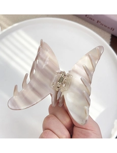 Detail of butterfly acetate hair claw clip with beige gradient and rhinestone accents