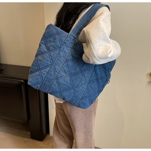 Détails de l'arrière d'un grand sac cabas en denim matelassé bleu foncé à losanges