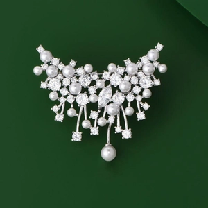 Elegant zircon butterfly pearl brooch with sparkling crystals on deep green background
