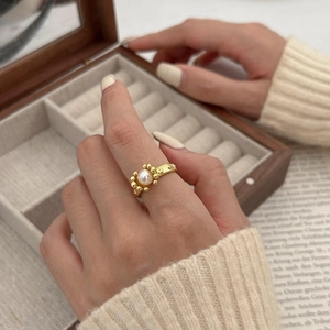 Detail of a vintage gold-plated silver ring with a white pearl and textured bamboo band
