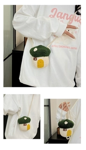 Detailed view of handmade mushroom-shaped knitted crossbody bag with woven shoulder strap