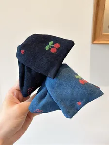 Détails des pinces à cheveux en denim avec broderie cerise en bleu foncé et clair