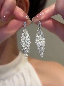 Macro shot of silver leaf tassel earrings featuring marquise-cut sparkling zircons