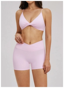 Détail d'un soutien-gorge de sport rose pâle col en V avec nœud et short de yoga taille haute