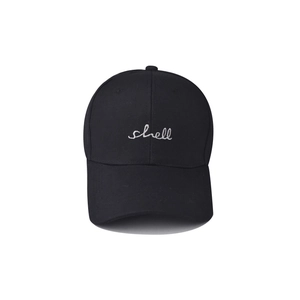 Detail view of white shell embroidery on black cotton canvas baseball cap surface