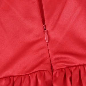 Close-up of red dress showing the invisible back zipper and ruched fabric detail