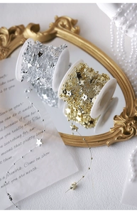 Detail of star-shaped pearl bead strands on reels in gold and silver finishes