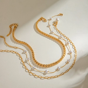 Collana multistrato dorata in acciaio con pendenti in perla e catena piatta a serpente