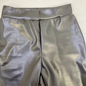 Dettaglio dei pantaloni a zampa neri a vita alta in ecopelle PU con finitura lucida