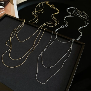 Detail of layered thin chain necklaces in gold and silver finish on a display tray