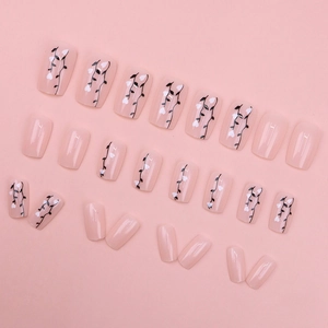 Pink press-on nails set with white heart and black vine patterns in glossy finish