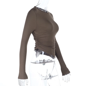 Detail of asymmetrical hemline and side ruching on a brown long sleeve slim-fit top
