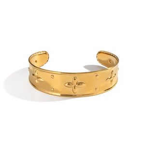 Vintage 18K gold-plated open bangle featuring embossed four-leaf clover motifs and metal studs