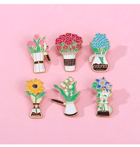 Flat lay of floral coffee enamel pins featuring tulips and roses in colorful cups