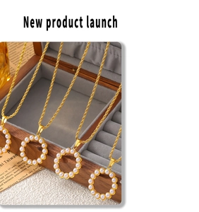 Detail of round gold pendant necklaces with white pearls on a vintage wooden jewelry box