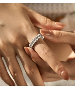 Close-up of elegant silver eternity ring featuring rectangular cut crystals on model hand