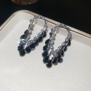 Detailed close-up of 18K gold plated drop earrings with black zircon and silver needles