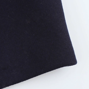 Close-up of the dark blue wool fabric texture and fine stitching on the lapel