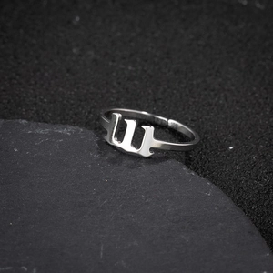 Macro detail of silver stainless steel gothic letter W adjustable open ring