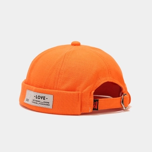 Detail of orange cotton docker cap with letter patch and adjustable metal buckle