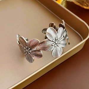 Detailed close-up of vintage silver floral bangle with antique finish and carved petals