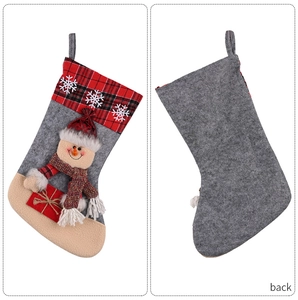 Detail of grey felt Christmas stocking with snowflake plaid cuff and 3D snowman applique
