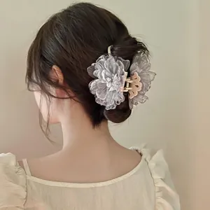 Detail einer eleganten grauen Organza Blumen Haarklammer am Modell mit weichem Licht