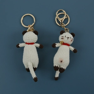 Handmade crocheted Siamese cat keychains with red collars and golden metal rings